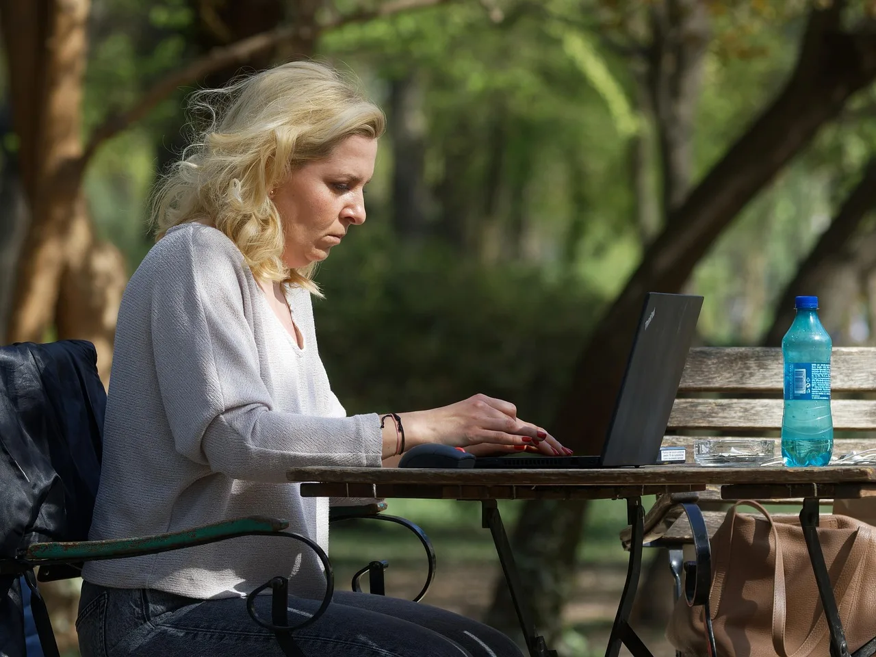woman, working, park, outdoors, work from anywhere, laptop, caucasian. Creator income tax by state: residency and filing rules