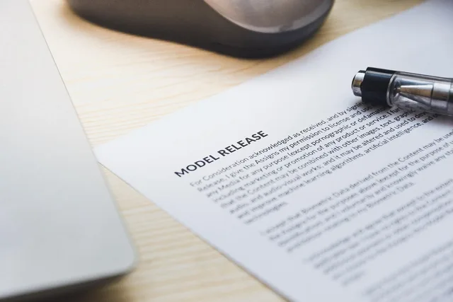 paper, model release, form, document, signing, pen, desk, agreement, business, contract, signature. Ever scroll through New York creator contracts?